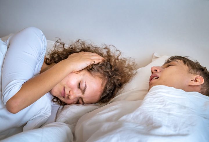 The wife is annoyed by her husband snoring.