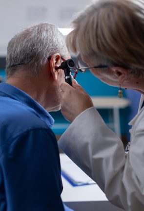 close-up-medic-using-otoscope-ear-examination-aged-patient-cabinet-general-practitioner-using-otolaryngology-instrument-healthcare-checkup-man-medical-visit